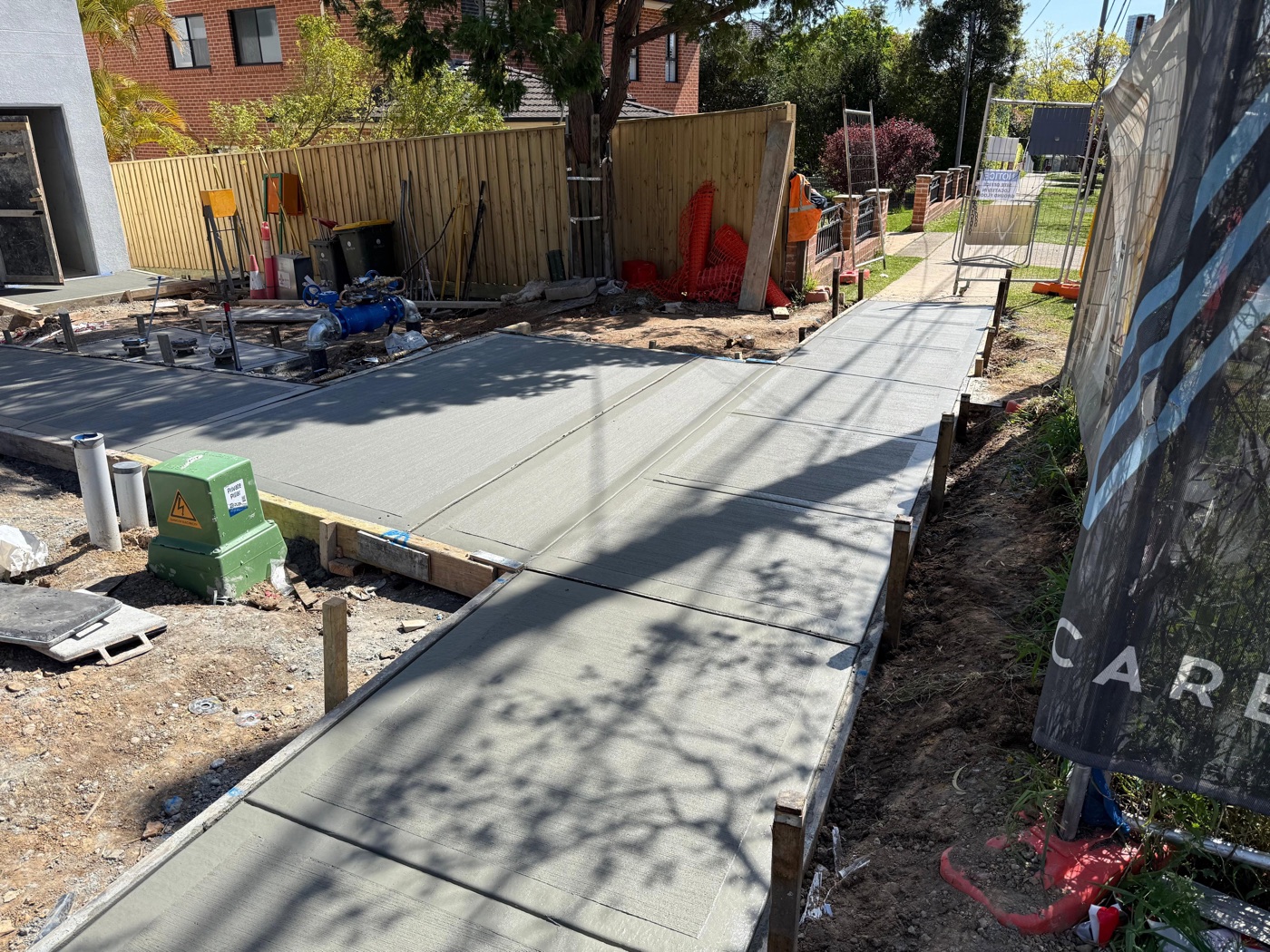 A freshly finished concrete footpath and slab