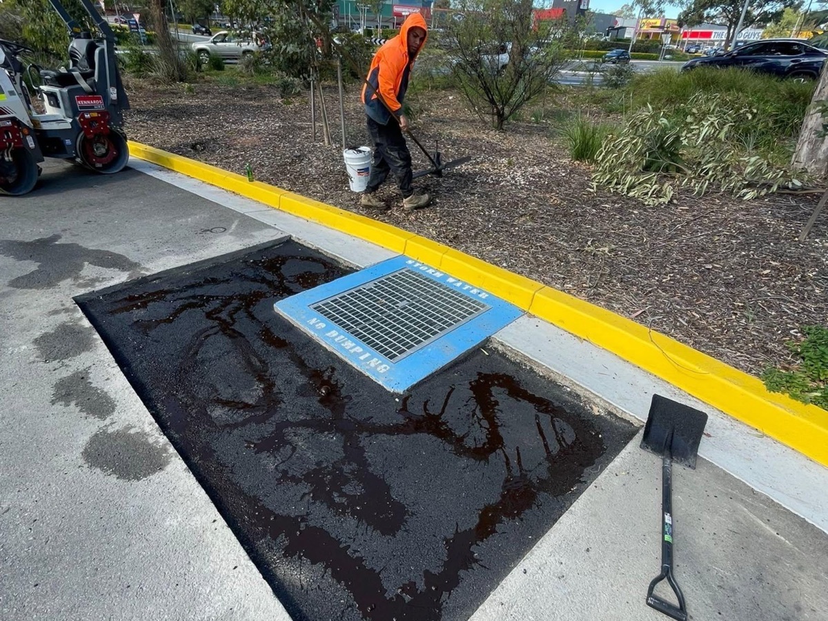 Civil Brothers crew preparing an asphalt patch around a stormwater drain